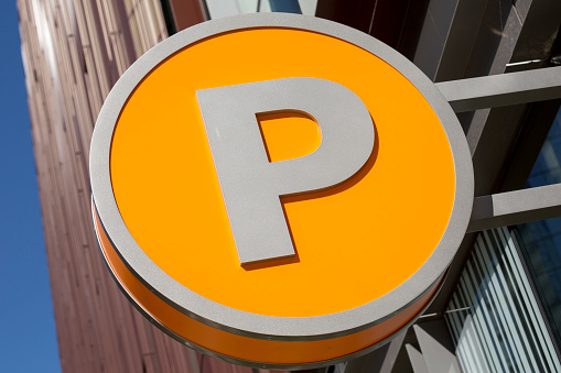 Capital P indicating parking, on a bright yellow parking sign in downtown Seattle.