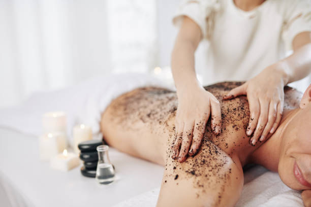 Massaging back with coffee scrub Beautifican massaging back of male client with coffee scrub and essential oil scrubbing stock pictures, royalty-free photos & images