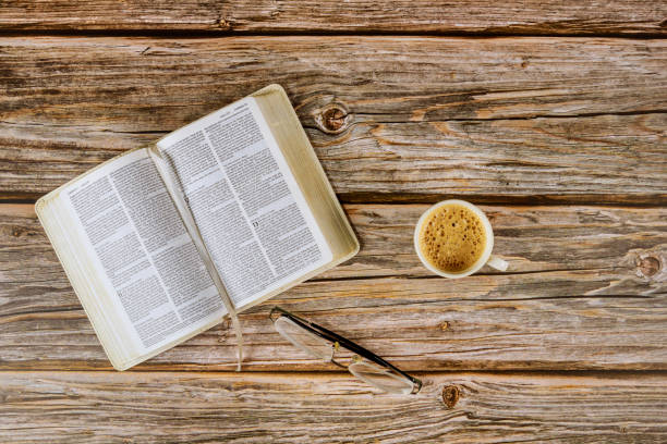 istock Open Bible morning readings on a table top with coffee cup and eyeglasses 1226855949