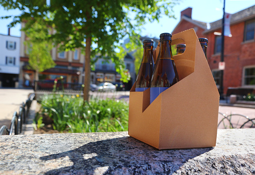Craft beer in a brown cardboard carrier, room for your copy in this downtown small town beer brewery stock photo