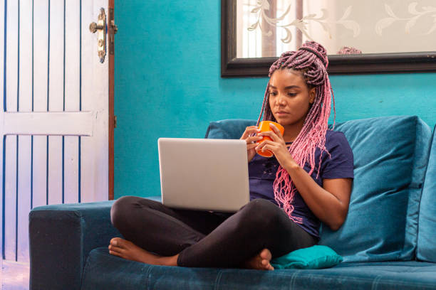 istock Young black woman with braid using notebook in home room 1226859668