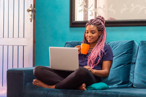 istock Young black woman with braid using notebook in home room 1226859669