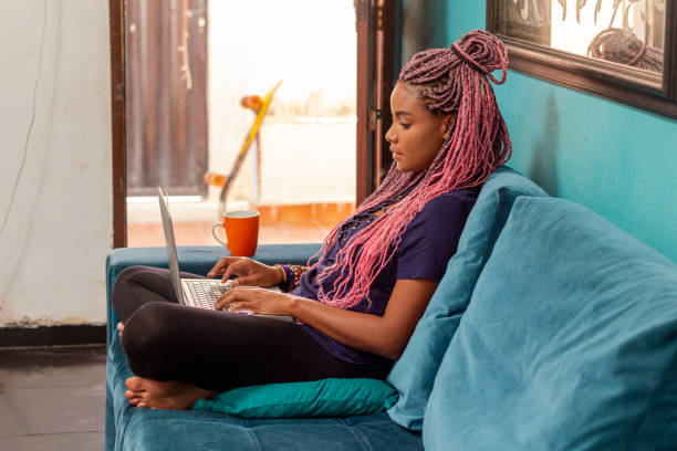 istock Young black woman with braid using notebook in home room 1226859681