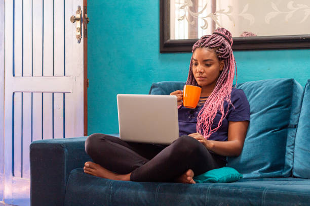 istock Young black woman with braid using notebook in home room 1226859682