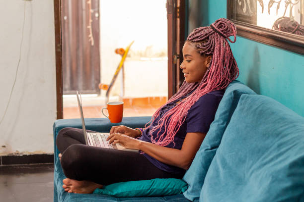 istock Young black woman with braid using notebook in home room 1226859697