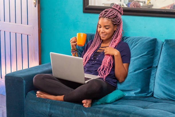 istock Young black woman with braid using notebook in home room 1226859711