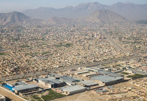 Mazar-i-Sharif, Balkh province, Afghanistan: city skyline - traditional adobe houses with backyards surrounded by tall walls -  Hindu Kush mountains in the background. Mazar-e-Sharif is the fourth largest city in Afghanistan.  The city is a major tourist attraction due to its fabulous Muslim and Hellenistic archaeological sites.