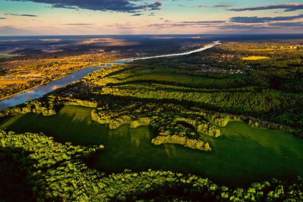 istock Beautiful light from setting sun on earth. Spring sunset. Aerial view of river from above. Light and shadow. Summer nature background. Drone landscape photography. Flying above earth 1226864298