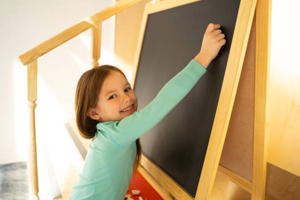 istock Cheerful little girl using chalkboard at home 1226867548