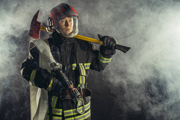 istock caucasian fireman with hammer risking his life to save people from fire 1226867698