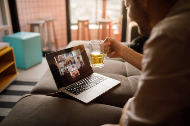 Man drinking with friends on social distance Man hanging out with friends on a video conference. new normal concept stock pictures, royalty-free photos & images