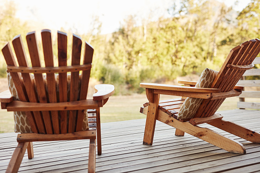 Shot of wooden chairs on a deck out in a garden