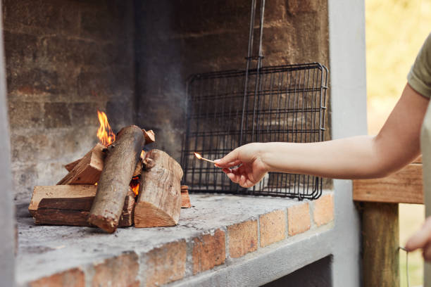 a good barbecue starts with a good fire - fire match women flame imagens e fotografias de stock