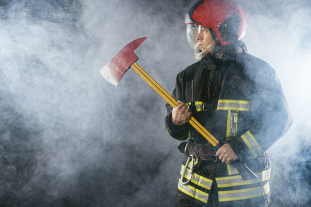istock caucasian fireman with hammer risking his life to save people from fire 1226868811