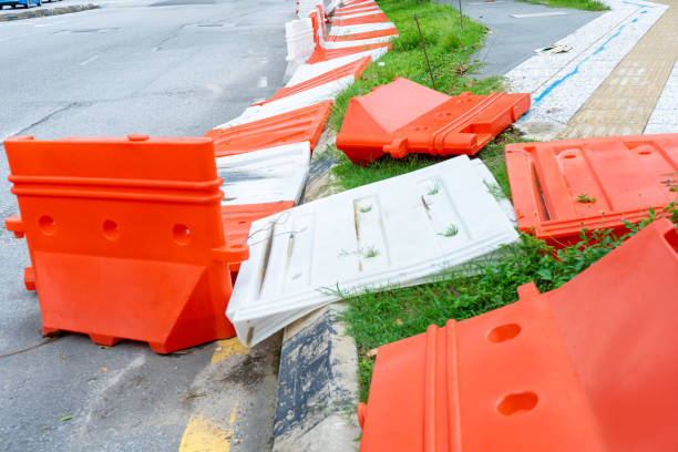 plastic blocks restricting the passage of cars during repair work. safe plastic road fences - cyclone fence imagens e fotografias de stock