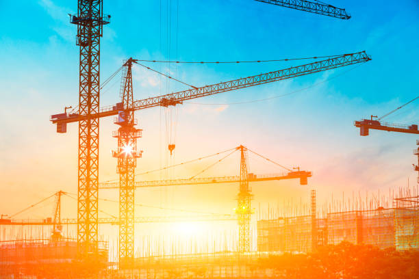 istock Tower crane and building construction site silhouette at sunrise. 1226871135
