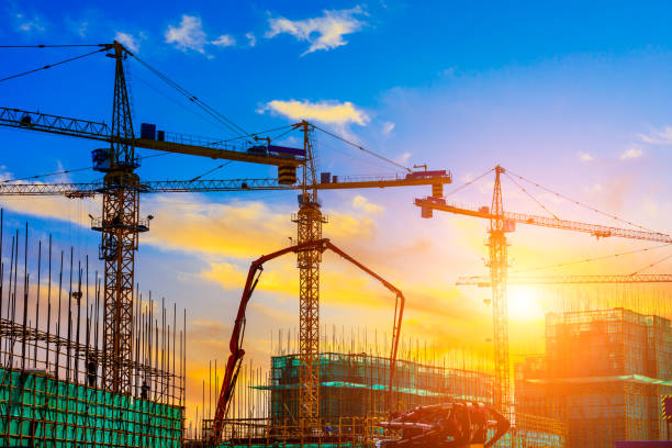 istock Tower crane and building construction site silhouette at sunrise. 1226871199