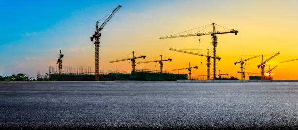 Asphalt road and construction site landscape at sunrise.