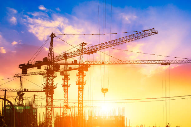 istock Tower crane and building construction site silhouette at sunrise. 1226871848