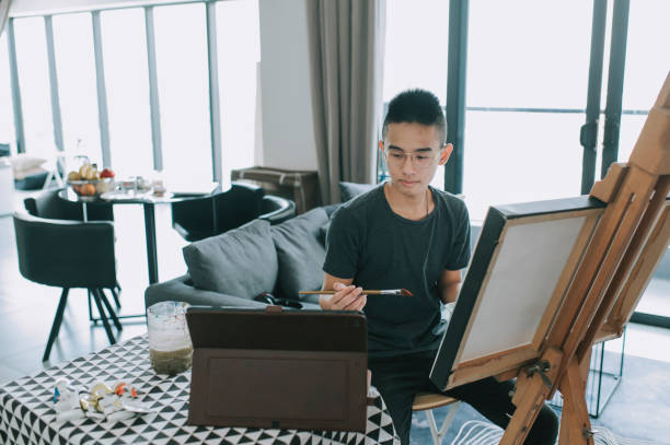 An Asian Chinese Teenager Drawing Acrylic Painting At Home In Living Room