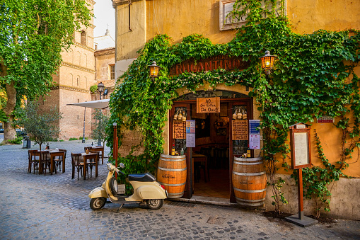 Rome, Italy, May 22 -- A typical roman restaurant with a scooter in the ancient Trastevere district, the most loved and visited district by the tourists of the ethereal city. Image in HD format.