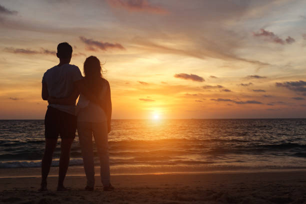 istock people silhouettes walking on beach coast to ocean at sunset 1226875539