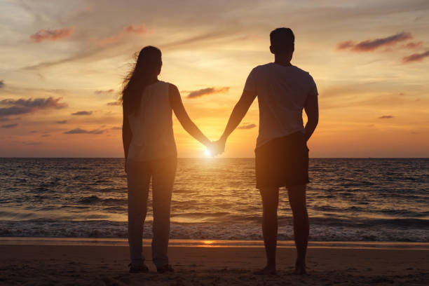 istock people silhouettes walking on beach coast to ocean at sunset 1226875540
