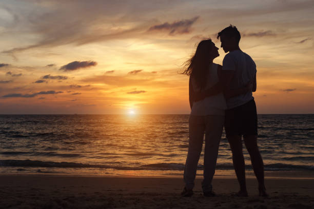 istock people silhouettes walking on beach coast to ocean at sunset 1226875541