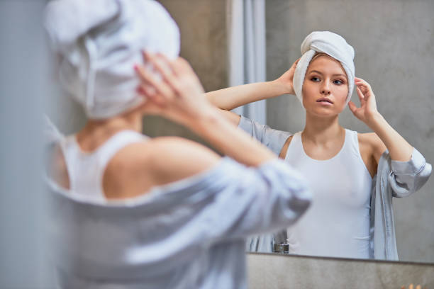 istock attractive lady look at mirror in bathroom 1226877614