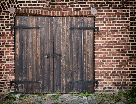 Old wooden stable door and brick wall