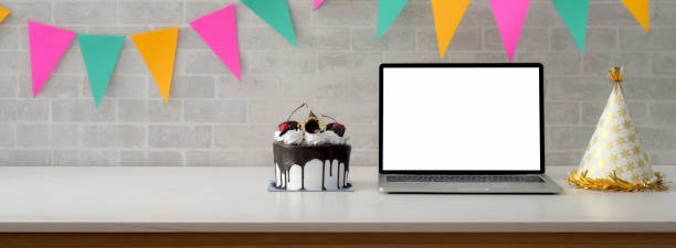istock Online birthday party concept with blank screen laptop, cake and copy space on white table 1226881194