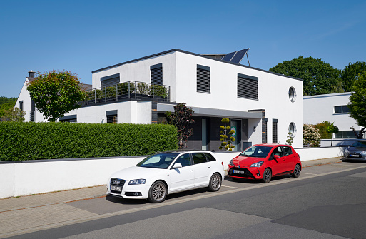 Kaarst, Germany - May 07, 2020: Modern luxury house in the housing area of Kaarst (close to Duesseldorf), a white Audi and a red Toyota is parked in front of the house.
