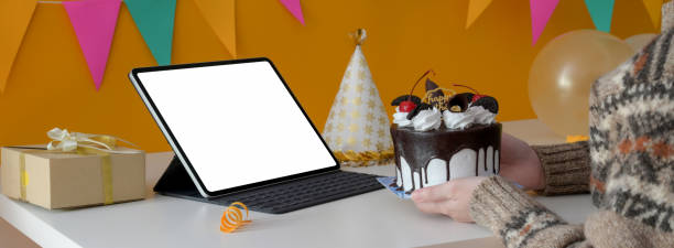 istock Online birthday party concept with blank screen tablet, cake, party hat and present box on white table 1226881589