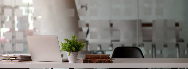 istock Glass partition office room interior design with laptop, document files, decorations and copy space on white table with black chair 1226881684