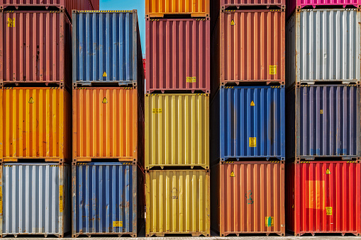 Multicolor shipping containers stacked high at a port.