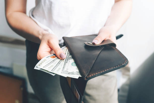 istock Wallet with dollar bills in female hands. 1226887421