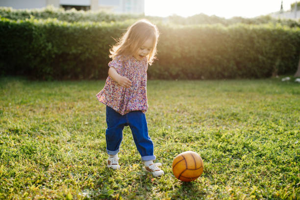 istock Little girl playing with ball front of backyard 1226887737
