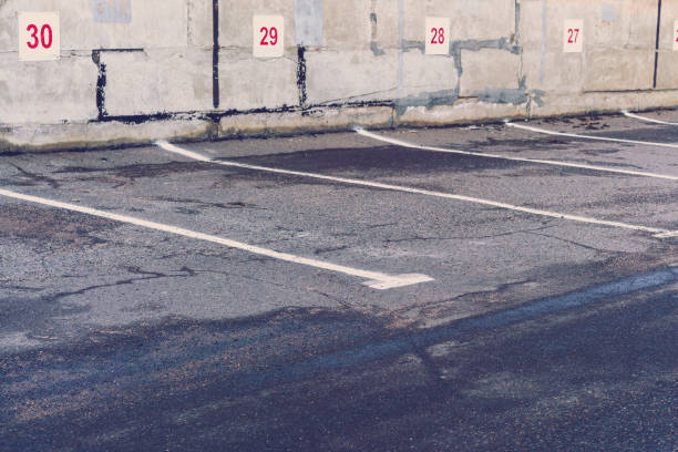 istock old empty parking lot with place numbers on grey concrete wall and wet asphalt 1226887837