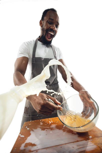 Amazing african-american man preparing unbelievable food with close up action, details and bright emotions, professional cook. Preparing omelet, mixing eggs with splashing milk