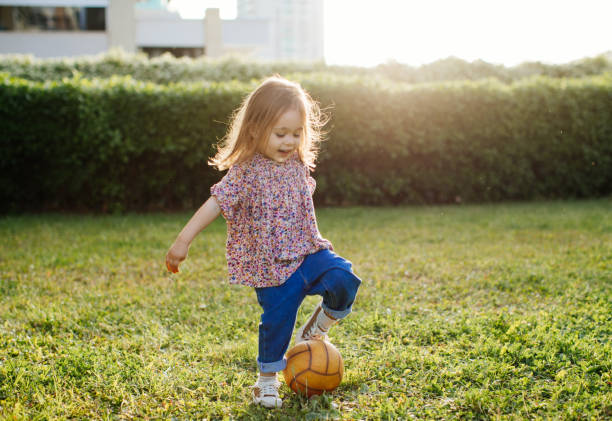 istock Little girl playing with ball front of backyard 1226888580