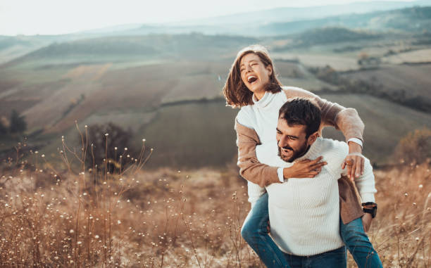 istock Young cheerful couple having fun while piggybacking on a hill. 1226888603