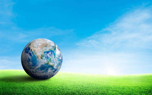 istock Blue planer earth on green grass meadow field with blue sky in background. 1226889102