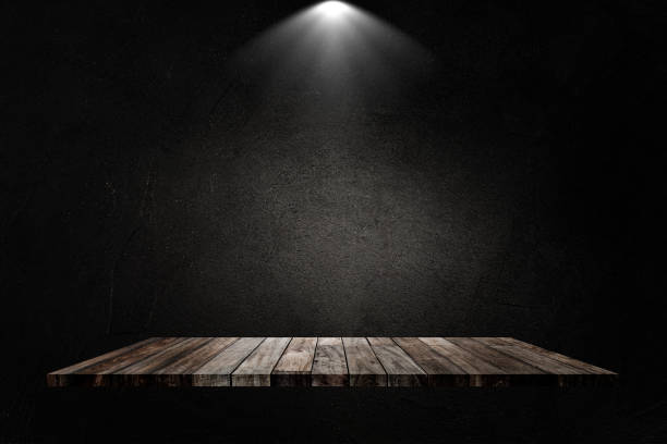 istock Black concrete grunge texture background with wooden shelf and spotlight. 1226889648