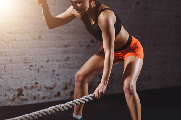 istock Powerful woman do workout with battle ropes in gym 1226890526