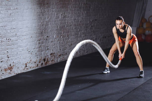 istock Woman doing gym exercise with one battle rope 1226890883