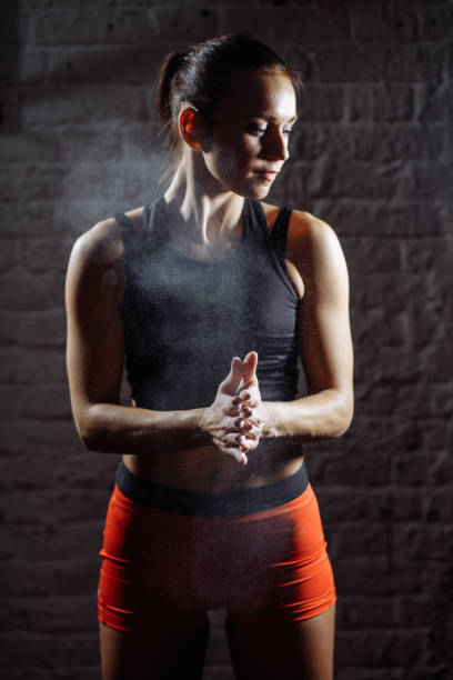 istock female athlete clapping hands with chalk powder before strength training 1226891687