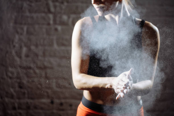 istock female athlete clapping hands with chalk powder before strength training 1226893530