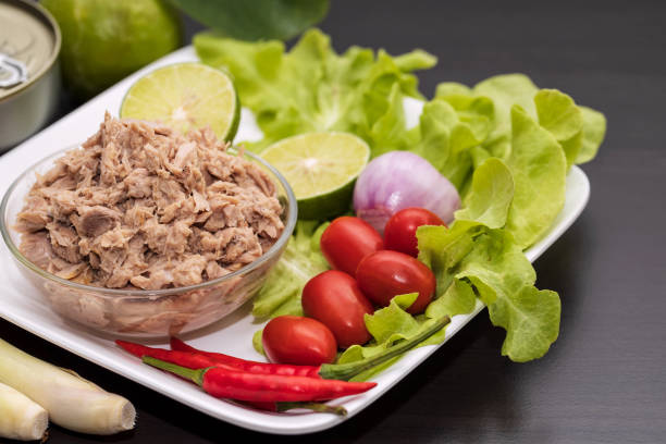 Tuna chunks in glass bowl with fresh vegetables salad. stock photo