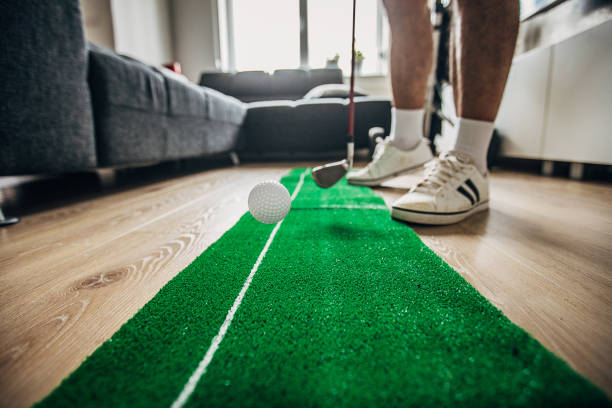 hombre jugando mini golf en la sala de estar - retirement golfer happiness relaxation fotografías e imágenes de stock