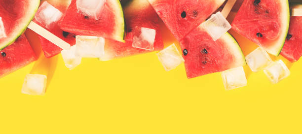 istock Watermelon slices with ice flat lay on yellow background 1226906087